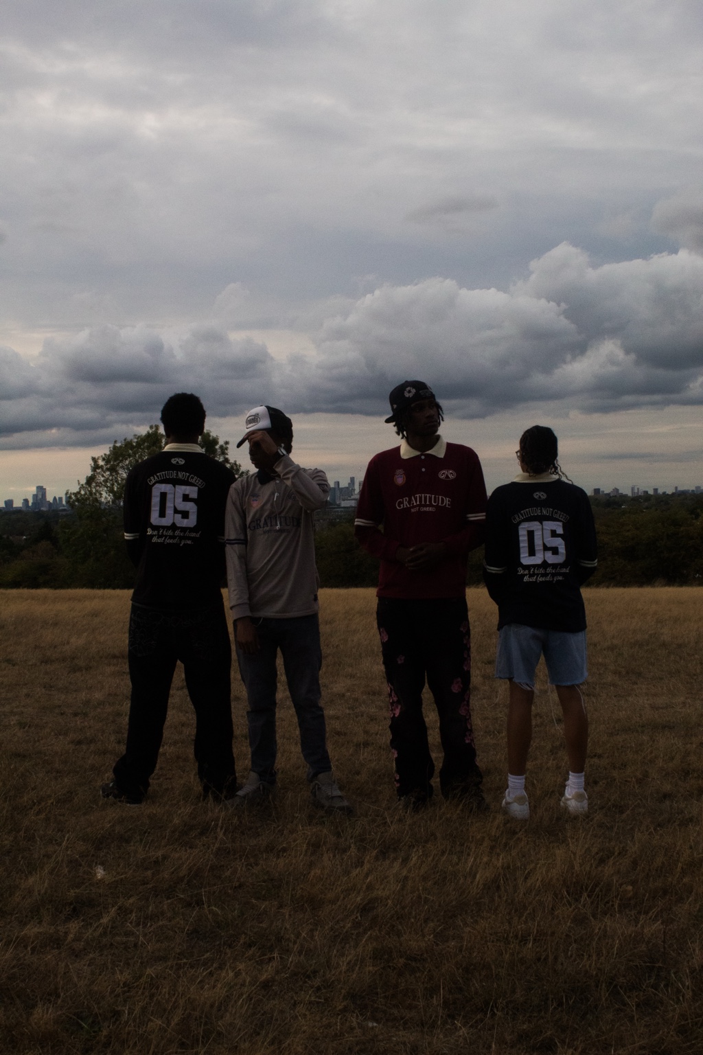 GNG campaign — five people in the grey, green, burgundy, brown and black rugby polos on Blackheath, London skyline behind